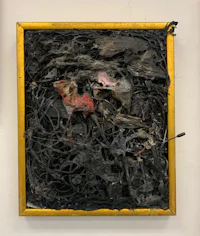a black and gold framed piece of art on a wall